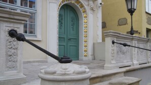 A building facade with a green door, white columns, and a black lamp post. - B&B HOTEL Gdańsk Old Town (Gdansk)