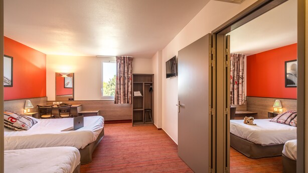 A hotel room with two beds, a desk, a chair, a TV, and a wardrobe. - Ace hôtel Annemasse Genève (Ville-la-Grand)