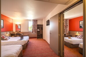 Habitació d'hotel amb dos llits, un escriptori, una cadira, un televisor i un armari.