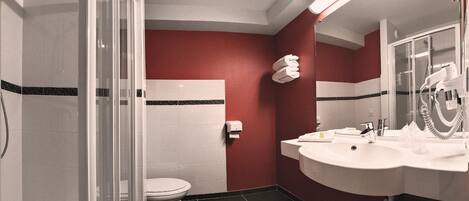 A bathroom with a toilet, sink, and shower.