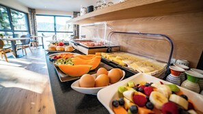 En buffé med ett varierat utbud av frukosträtter, inklusive ägg, frukt och bakverk.