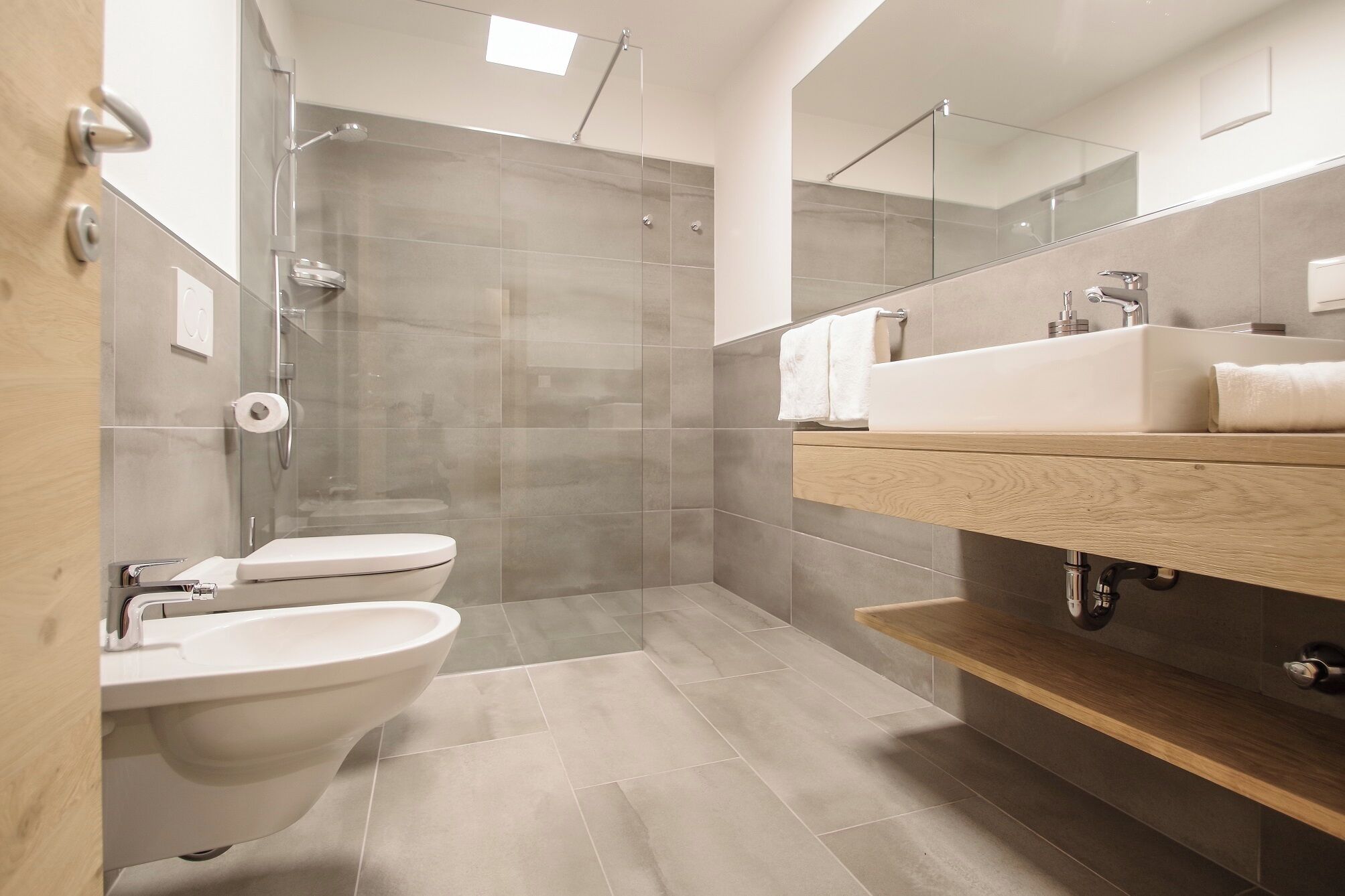 Un baño moderno con ducha, inodoro y lavamanos.