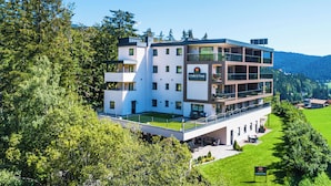 Un hotel moderno de varios pisos con techo plano, ventanas amplias y un letrero que dice "CHRISTINE".