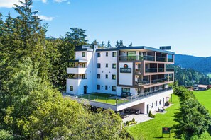 A modern multi-story hotel with a flat roof, large windows, and a sign reading "CHRISTINE".