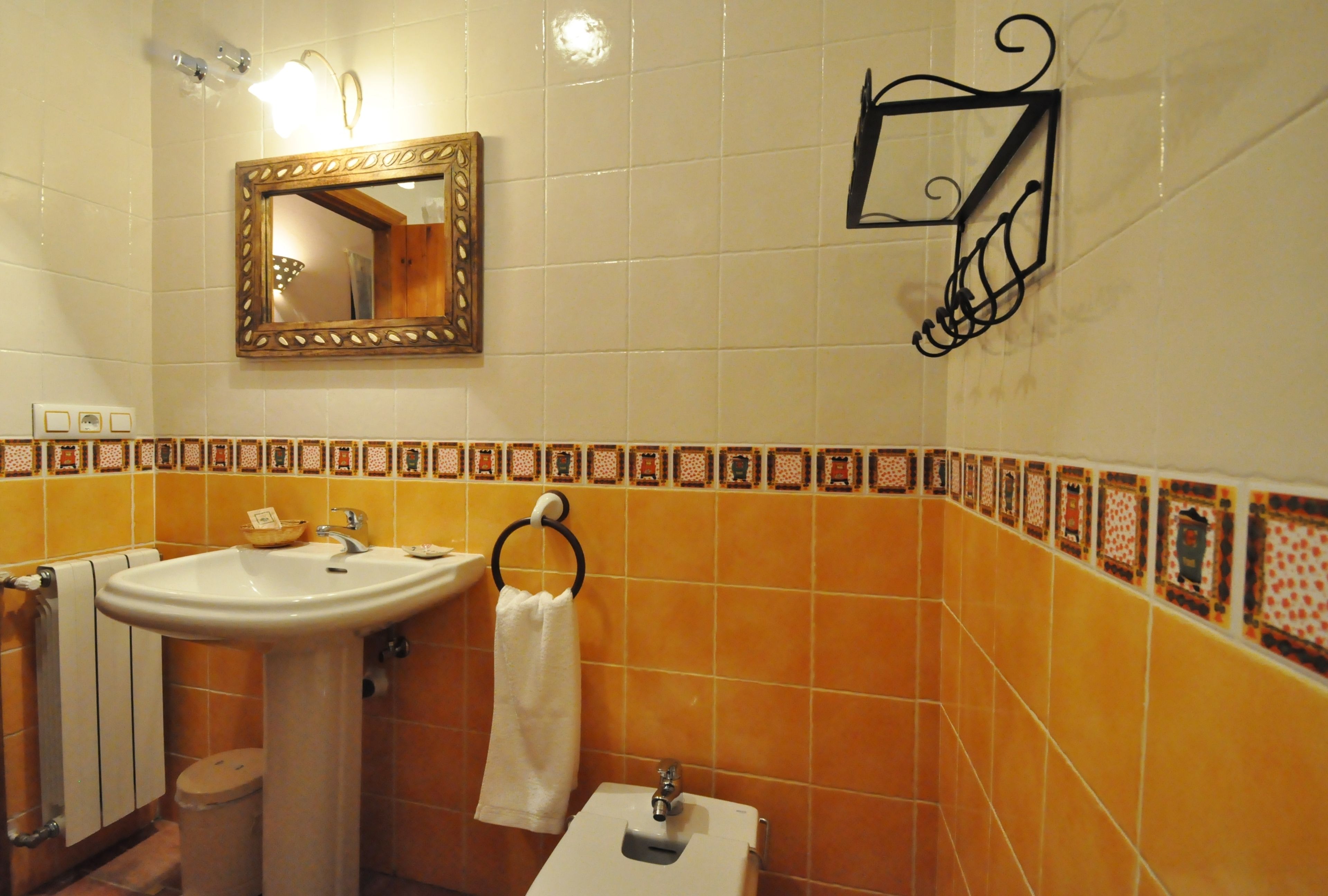 Une salle de bain équipée d’un lavabo, d’un miroir, d’un porte-serviettes et de toilettes.