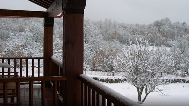 A wooden balcony with a view of a snow-covered landscape. - Hotel Rural Aguallevada (Robleda-Cervantes)