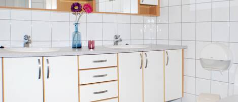 A bathroom with two sinks, a mirror above the sinks, and a toilet.