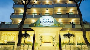 Entrada de um hotel com uma placa indicando 'HOTEL CANNES'.