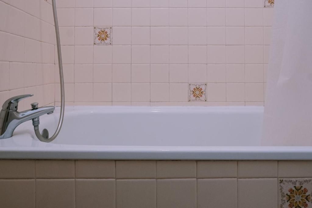 A bathroom with a bathtub, a shower, and a faucet.