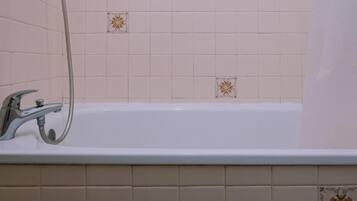 A bathroom with a bathtub, a shower, and a faucet.