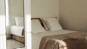 A bedroom with a bed, pillows, and a mirror. - Creste e Mare (Ajaccio)