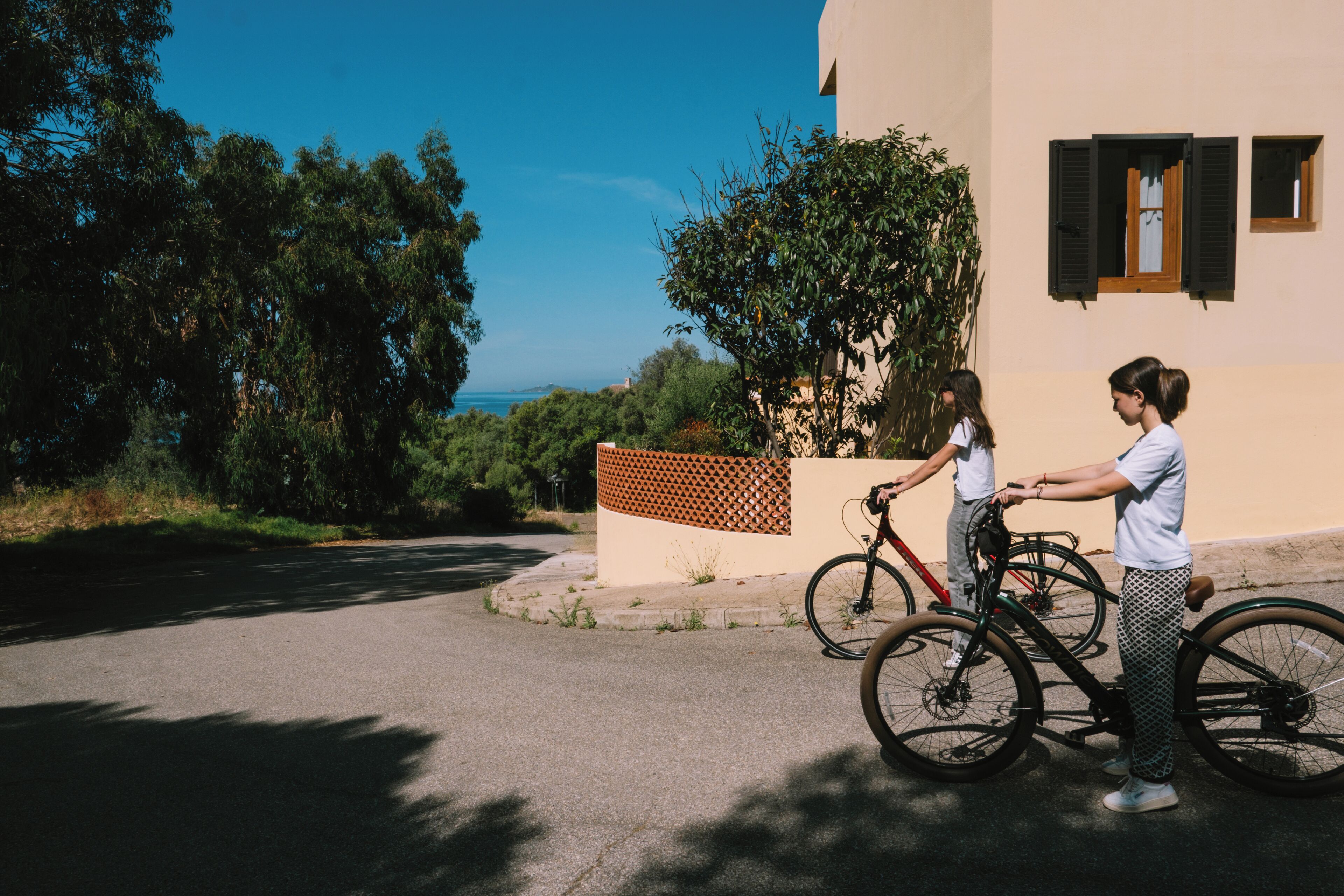 A building with a paved driveway and a bicycle parked in front.