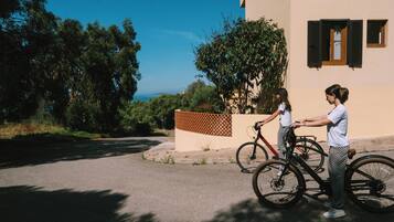A building with a paved driveway and a bicycle parked in front.