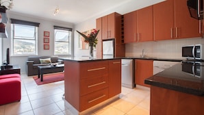 Een moderne keuken met houten kasten, een centraal eiland en een inbouwvaatwasser.