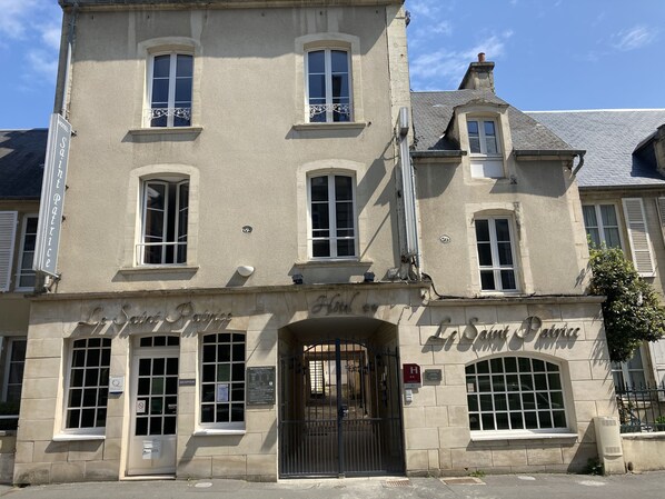 A historic building with a sign reading "Le Saint Patrice." It features a traditional facade with multiple windows and a central entrance. - Hôtel Le St Patrice (Bayeux)