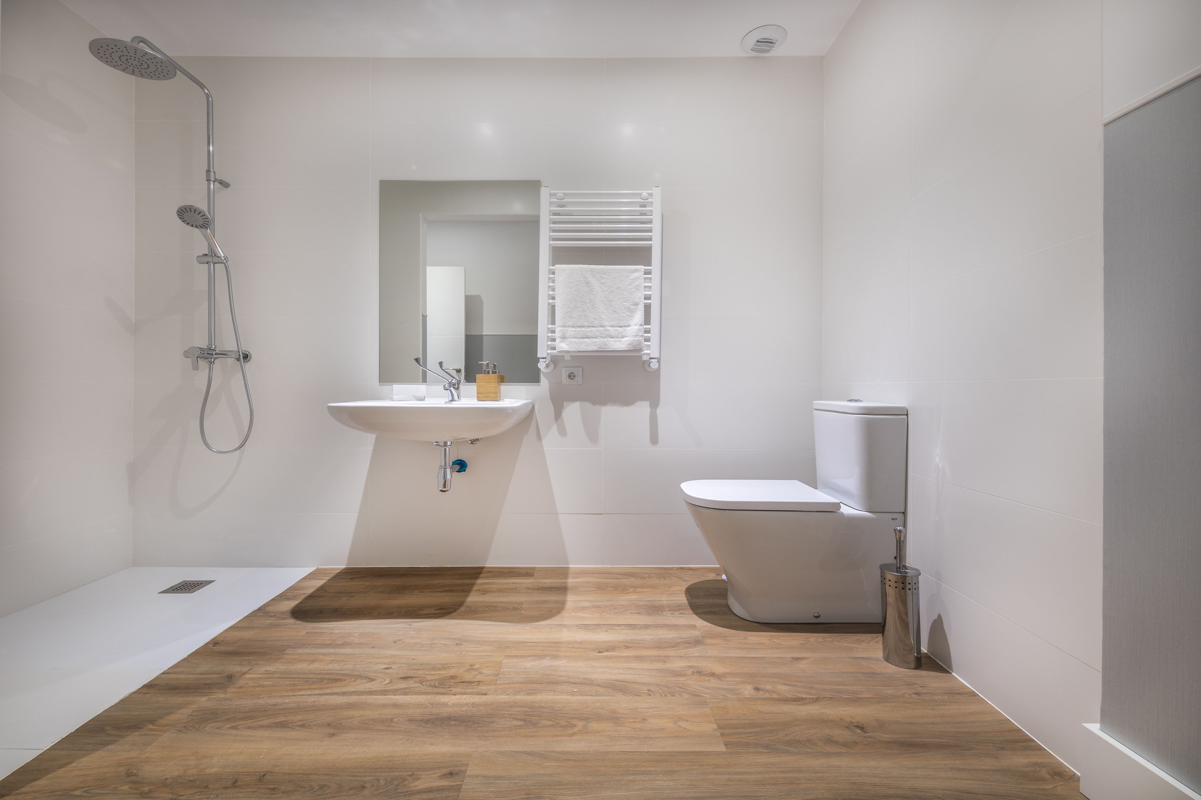A modern bathroom with a shower, sink, and toilet.