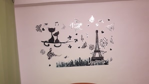 A bedroom with a bed, a headboard, and a wall decoration featuring the Eiffel Tower and musical notes. - Depto Pedro Prado en Iquique 1119 (Iquique)
