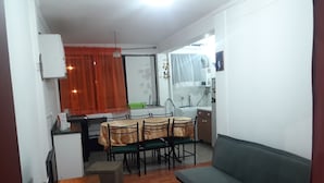 A compact living space with a dining area, kitchenette, and a sofa. - Depto Pedro Prado en Iquique 1119 (Iquique)