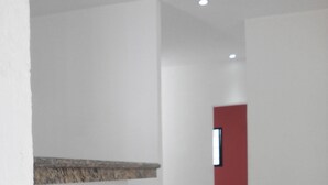 A corridor with white walls and a red door at the end. - Casa en PlayaDelCarmen 526 by Sinbad (Playa del Carmen)