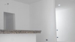 A spacious, modern interior with a minimalist design, featuring a central island counter and recessed ceiling lighting. - Casa en PlayaDelCarmen 526 by Sinbad (Playa del Carmen)