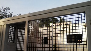 A modern building with a concrete facade, a metal gate, and a small plant in the foreground. - Casa en PlayaDelCarmen 526 by Sinbad (Playa del Carmen)