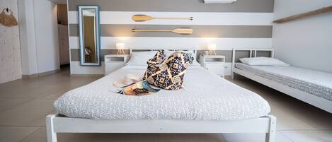 Un dormitorio moderno con una cama grande, dos mesitas de noche, un espejo y un ventilador de techo.