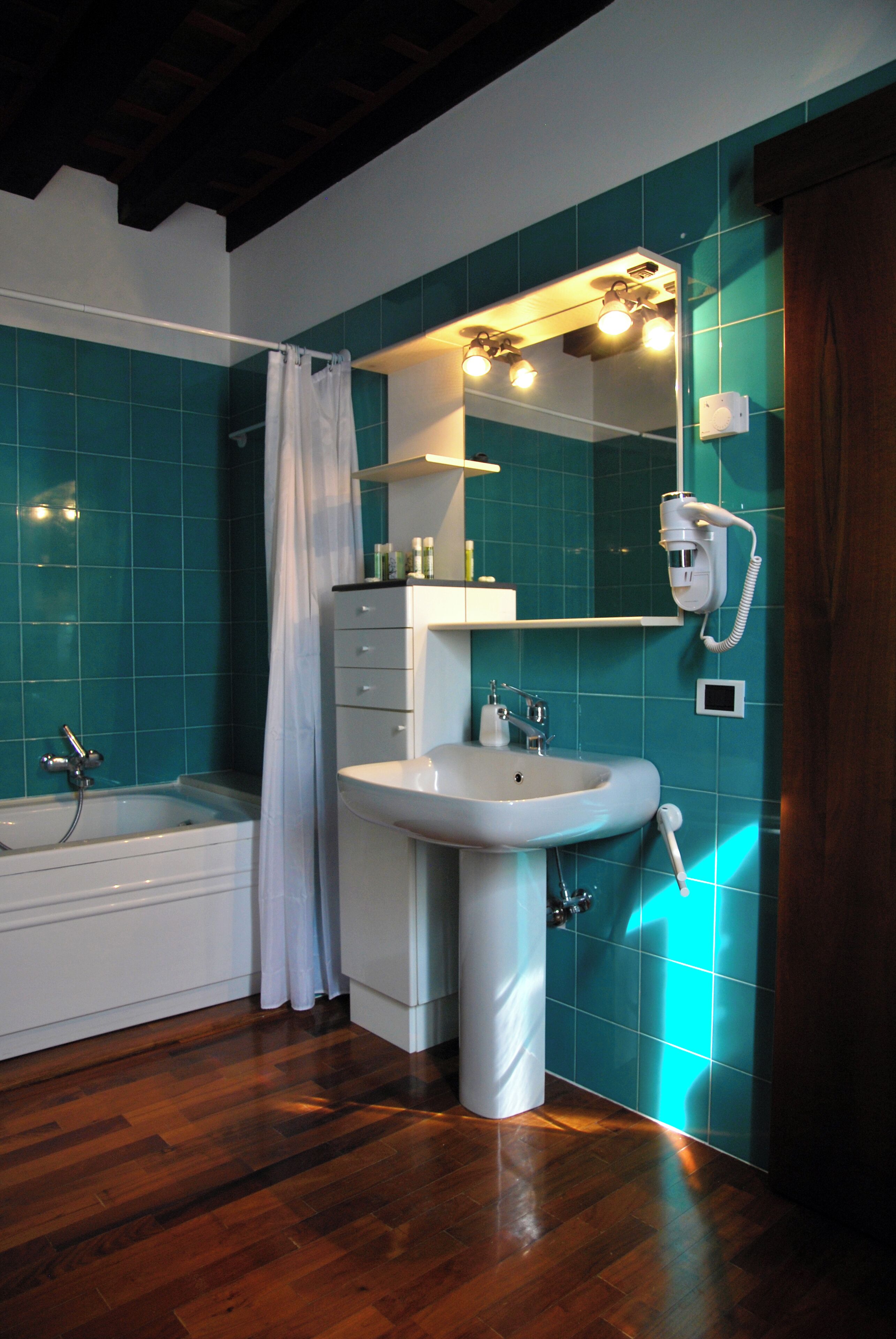 Un baño con bañera, lavamanos y espejo.