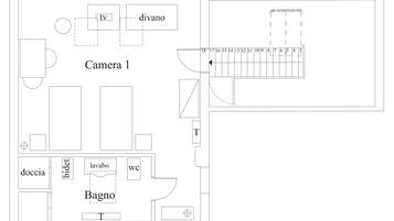Un plan d’étage indiquant les différentes pièces, notamment une salle de bain, des toilettes et un espace pour la télévision.