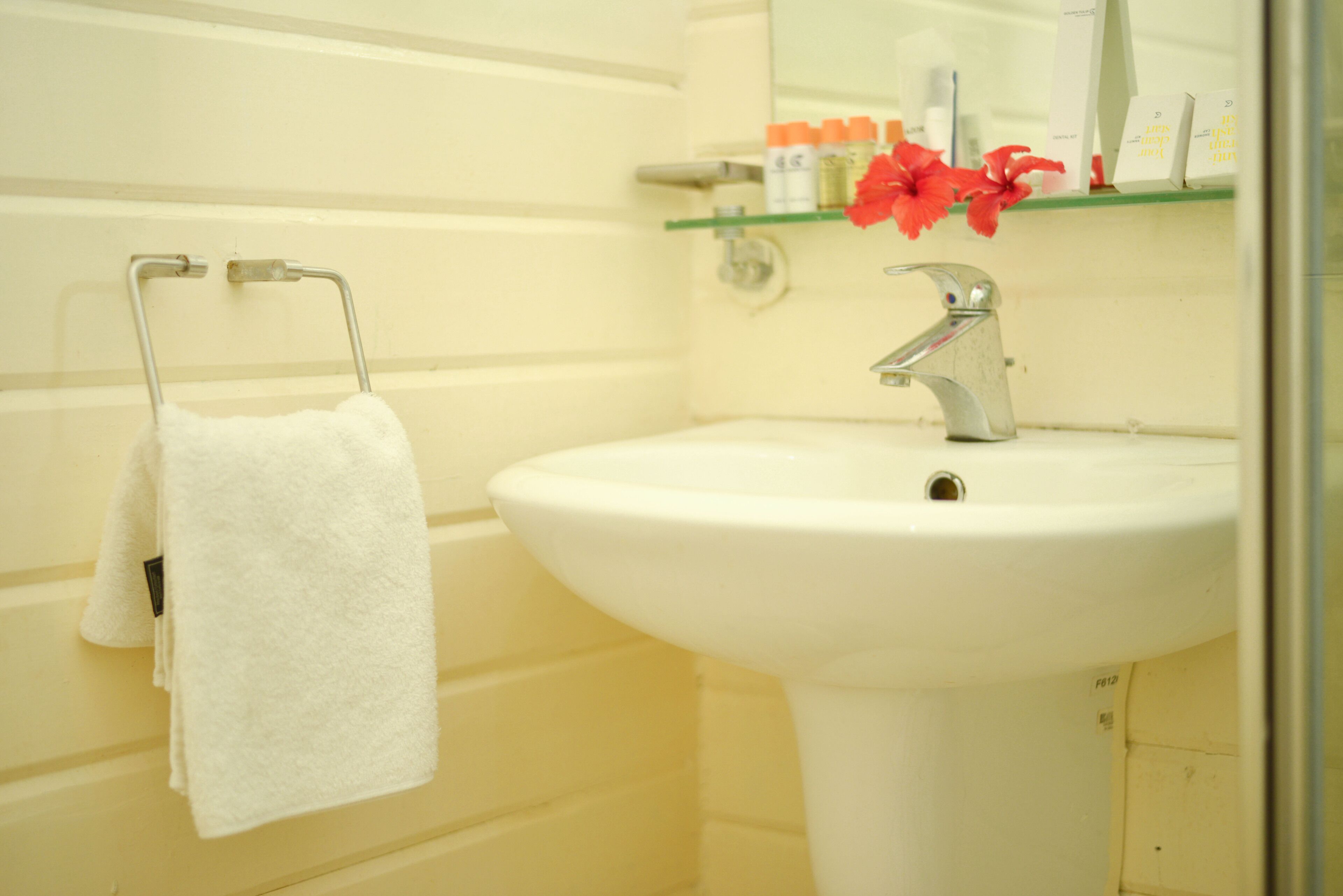 A bathroom with a white sink, a towel rack, and a mirror above the sink.