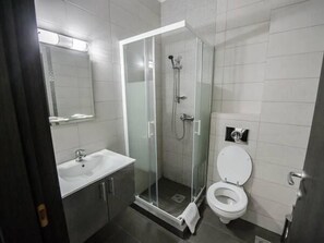 A modern bathroom with a glass-enclosed shower, a white sink, and a toilet. - La mer Mamaia Nord (Navodari)