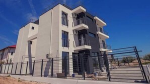 A modern two-story building with balconies and large windows.
