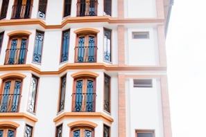 A multi-story building with arched windows and balconies, featuring a consistent architectural style. - Hotel Suiza Peruana (Huaraz)