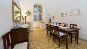 Ein Essbereich mit Mosaikboden, Holzmöbeln, einem großen Fenster mit Aussicht und an Wänden befestigter Kunst.