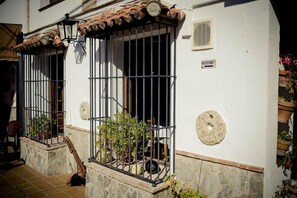 A building with barred windows, a stone base, and a tiled roof.