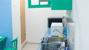 A compact kitchen with a sink, a dish rack, and a green cabinet. - Apartamento en PlayaDelCarmen 523 by Sinbad (Playa del Carmen)