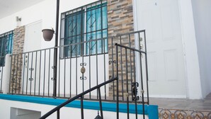A building with a white exterior, a blue trim, and a metal railing. - Apartamento en PlayaDelCarmen 523 by Sinbad (Playa del Carmen)