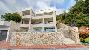 A multi-story building with a stone facade, balconies, and a sign indicating a location. - Villa Katarina 3 (Dubrovnik)