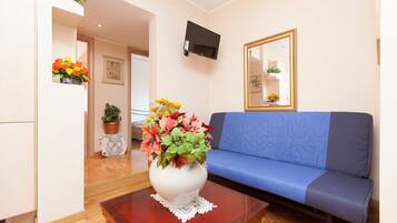 Apartamento, 4 quartos | Área de estar | TV de tela plana