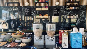 Et område med bar, kaffemaskine, snacks og et udvalg af drikkevarer.