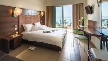Ein Hotelzimmer mit Bett, Nachttisch und Meerblick.