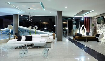 A modern lobby with a white sofa, a glass coffee table, and a unique bicycle design.
