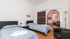 Una habitación de hotel con dos camas, un escritorio, una silla y un sofá.