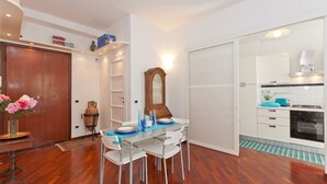 A compact kitchen with white cabinets, a stove, and a sink. - Rental In Rome Pateras Flower (Rome)
