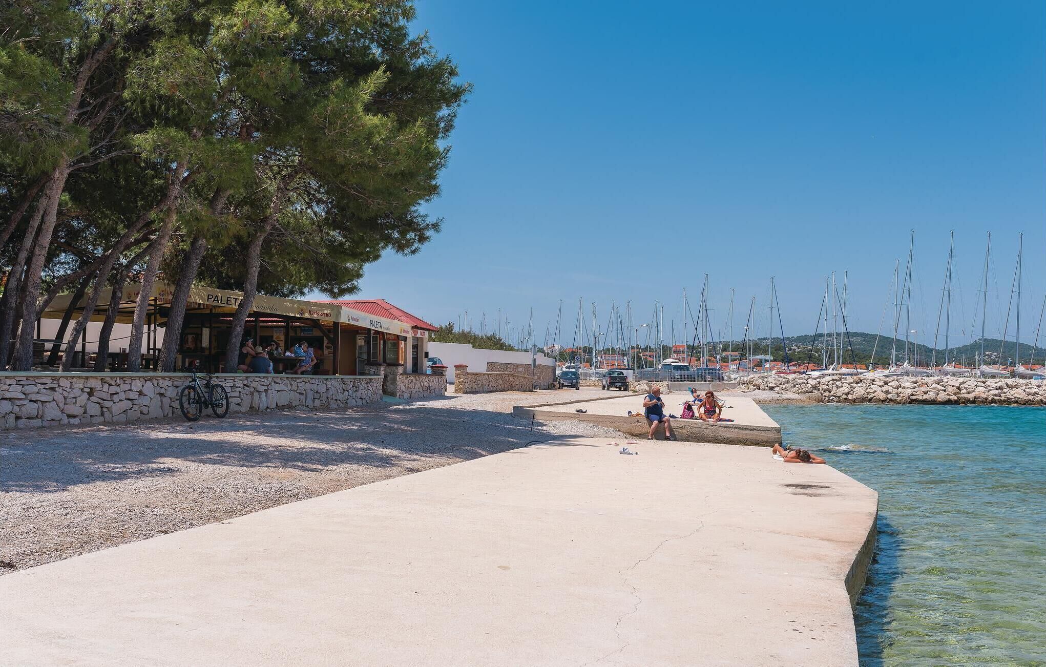 A coastal area with a restaurant named "PALET" and a marina with boats.