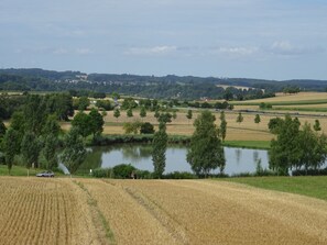 A rural landscape with a field, a pond, and a road with vehicles. - spacious holiday apartment "Turm im Blick" in attractive surroundings, (Dietingen)