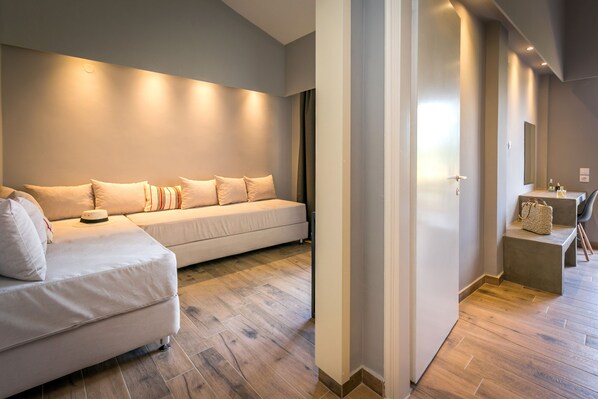 Moderni hotellihuone, jossa on suuri sänky, sohva ja pieni oleskelualue.