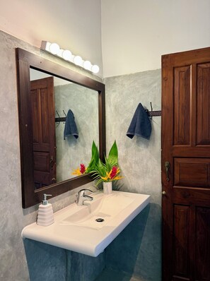 A bathroom with a white sink, a large mirror, and wooden doors. - Peaceful, private self contained villa. Just a few steps from the beach! (Tangalle)