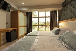 A hotel room with a bed, a desk, a TV, and a view of the outside. - Hotel Montedobra (Torrelavega)