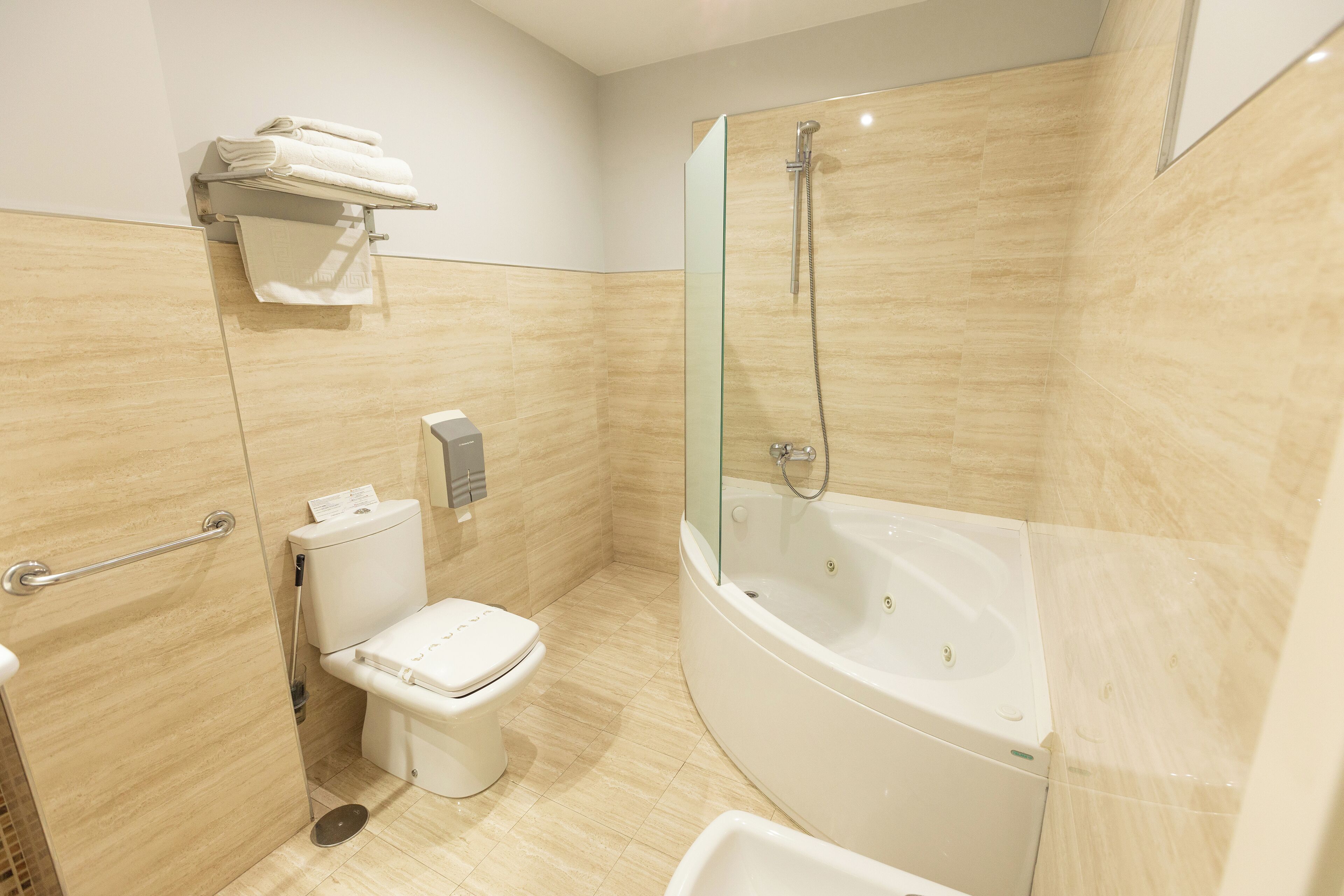 A modern bathroom with a glass-enclosed shower, a white toilet, and a bathtub.