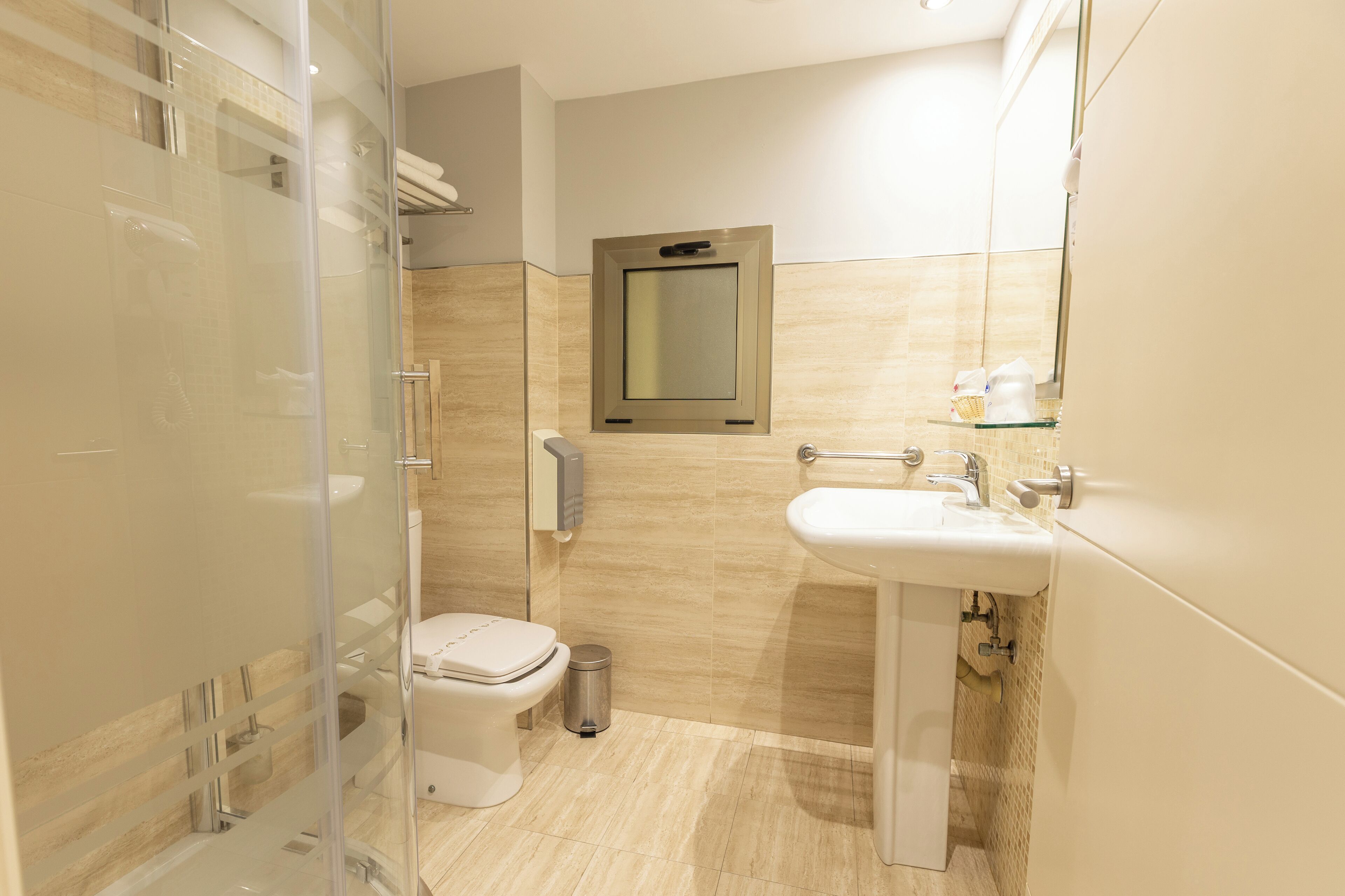 Une salle de bain moderne avec une douche à parois de verre, des toilettes, un lavabo et un miroir.